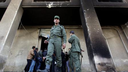 A Syrian army soldier steps out from the burned court building that was set on fire by Syrian anti-government protesters, in the southern city of Daraa, Syria, on Monday March 21, 2011. Mourners chanting No more fear! have marched through a Syrian city where anti-government protesters had deadly confrontations with security forces in recent days. The violence in Daraa, a city of about 300,000 near the border with Jordan, was fast becoming a major challenge for President Bashar Assad, who tried to contain the situation by freeing detainees and promising to fire officials responsible for the violence. (AP Photo/Hussein Malla)