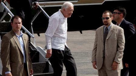Former President Jimmy Carter, second from left, arrives to the Jose Marti airport in Havana, Cuba, Monday, March 29, 2011. Carter is in Cuba to discuss economic policies and ways to improve Washington-Havana relations, which are even more tense than usual over the imprisonment of a U.S. contractor on the island. (AP Photo/Franklin Reyes)