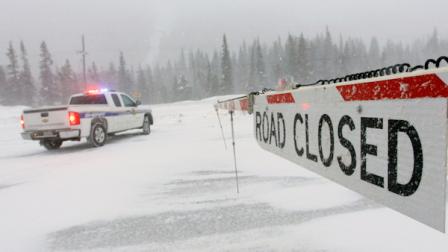 Colorado State Patrol automobile is parked at the closure of Colorado Highway 40 near Berthoud pass, Empire, Colo. on Wednesday, March 30, 2011, due to an avalanche that spans the road 50 feet long and ten feet high. State Patrol has requested to travelers to turn around and enter through another pass to Winter Park and Steamboat Springs. It will take several hours to have CDOT clear the way for travelers. (AP Photo/Nathan Bilow)