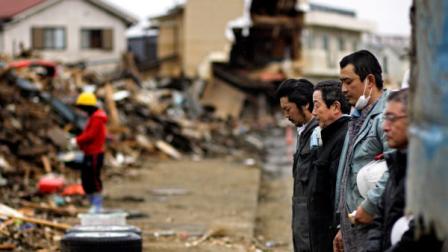 Japanese stop for a moment of silence at 2:46pm, exactly a month after a massive earthquake struck the area in the port town of Kesennuma, Miyagi Prefecture, Japan, Monday, April 11, 2011.