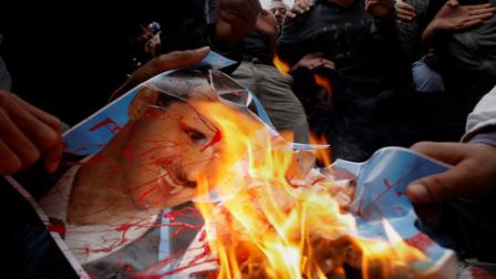 Syrian protestor burn a poster of Syrian president Bashar Assad during a demonstration in front of the Syrian embassy in Nicosia, Friday, April 22, 2011. Several hundred Syria protesters resident in Cyprus have called for Syrian President Bashar Assads ouster. (AP Photo/Petros Karadjias)