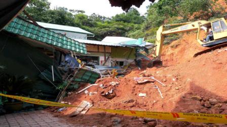A rescuer uses a construction machine to search for the bodies believed to be buried by a landslide in Hulu Langat in central Selangor state, outside Kuala Lumpur, Malaysia, Saturday, May 21, 2011. Police say about 30 children were buried by the landslide that hit an orphanage Saturday. (AP Photo)