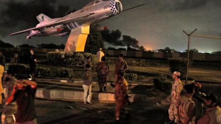Pakistani rangers and rescue workers gather at the main gate of a naval aviation base following an attack by militants, in Karachi, Pakistan, Sunday, May 22, 2011. Militants attacked a naval aviation base in the southern Pakistani city of Karachi late Sunday, rocking the base with explosions and battling commandos sent in to subdue the attackers, security officials said. (AP Photo/Shakil Adil)
