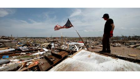 Brent Long looks over a devastated Joplin, Mo. neighborhood as he helps a friend salvage belongings Monday, May 30, 2011. An EF-5 tornado tore through much of the city May 22, damaging a hospital and hundreds of homes and businesses and killing at least 139 people. (AP Photo/Charlie Riedel)