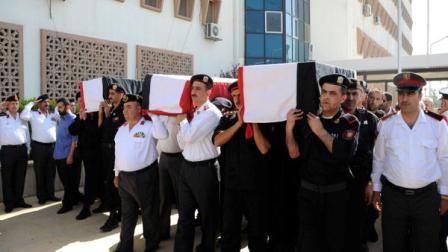 In this photo released by the Syrian official news agency SANA and according to them, Syrian policemen carry the coffins of their comrades who were killed in recent violence in the country, during their funeral procession at the Police Hospital in Damascus, Syria on Tuesday, June 7, 2011. Residents fled the northern region of Jisr al-Shughour on Tuesday where authorities said weekend clashes between armed men and government troops killed 120 security forces, fearing retaliation from a regime known for ruthlessly crushing dissent.