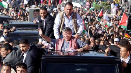 In this Saturday, June 11, 2011 photo released by the Jordan Royal Palace Jordans King Abdullah II, center, waves to people from his car during celebrations, in Amman, Jordan. In a speech marking his 12th year as Jordans ruler, Jordans king says future Cabinets will be formed according to an elected parliamentary majority. It is the first time that Abdullah II made such a concession publicly to his citizens. Jordanians have been demanding that the king loosens his absolute grip on power, which includes appointing prime ministers and Cabinets.