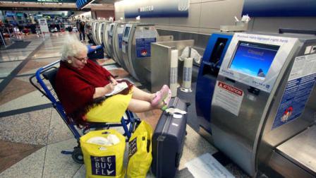 Stranded United Airlines passenger Rumi Harberts, of Amsterdam, waits at the United Airlines ticket counter at Denver International Airport Friday, June 17, 2011, in Denver. (AP Photo/Rick Bowmer)