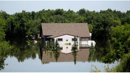 A home on the west side of Minot, N.D. is mirrored by the rising Souris River Thursday, June 23, 2011 in Minot, N.D. Officials in North Dakotas fourth-largest city said Thursday they had done all they could to protect critical infrastructure from the rising Souris River as it headed toward a record flood. (AP Photo/Charles Rex Arbogast)