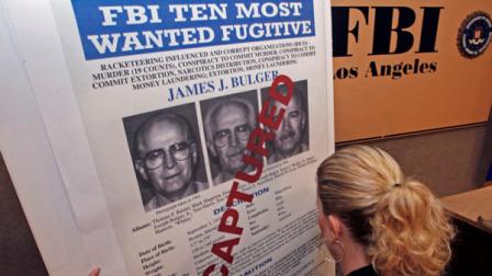 FBI Special Agent Mary Prang sets up a wanted poster overstamped captured for James Whitey Bulger, before a news conference at FBI headquarters in Los Angeles Thursday, June 23, 2011. (AP Photo/Reed Saxon)