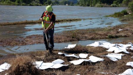An ExxonMobil contractor cleans up oil along the banks of the Yellowstone River in Billings, Mont., Sunday, July 3, 2011. A company pipeline about 20 miles upriver near Laurel, Mont., ruptured and spilled an estimated 1,000 barrels of crude into the Yellowstone on Saturday. (AP Photo/Matthew Brown)