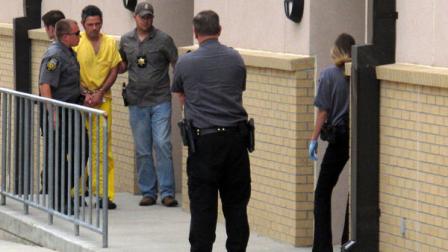 Law enforcement officers escort Everett E. Conant III into Platte County jail in Wheatland, Wyo. on Friday, July 8, 2011 after a court hearing. Conant has been charged with killing his three sons and adult brother and wounding his wife in a string of shootings in the small farming and ranching town. (AP Photo/Ben Neary)