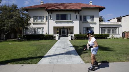 A woman passes the historic Spreckels mansion Thursday, July 14, 2011, in Coronado, Calif. A woman found dead at the historic mansion was nude and hanging from a balcony with her hands tied behind her back and her feet bound, investigators said Thursday. (AP Photo/Gregory Bull)