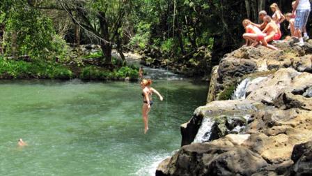 In a photo made July 6, 2011, a woman jumps into Kipu Falls in Lihue, Hawaii, on the island of Kauai. But the alluring beauty of the waterfall and natural pool conceals a deadly side. Five visitors to Kauai, all male, have drowned at Kipu Falls in the past five years.