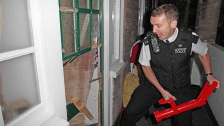 Sergeant Nash of the Westminster Burglary Squad enters a property in Westminster, London, Thursday Aug. 11, 2011, as police attempt to recover property stolen during the recent civil disturbances. Britains Prime Minister David Cameron promised vigorous and wide-ranging measures to restore order and prevent riots erupting again on Britains streets - including taking gang-fighting tips from American cities. Cameron told lawmakers there would be no culture of fear on Britains streets, as police raided houses to round up more suspects from four days of rioting and looting in London and other English cities.