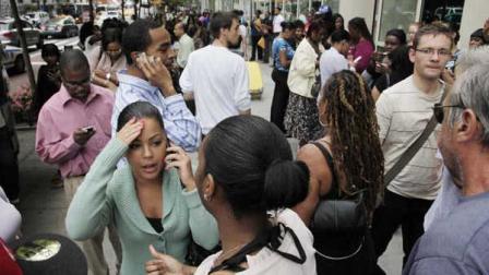 Office workers gather on a sidewalk after their building was evacuated following an earthquake in New York on Tuesday, Aug. 23, 2011.