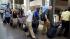 Travelers wait in line to board Amtraks...