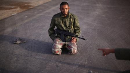 Rebel fighter Ani Saklen, 25, a mobile phone vendor, chats with a colleague at a checkpoint between Tarhouna and Bani Walid, Libya, Monday, Sept. 5, 2011. Negotiations over the surrender of one of Moammar Gadhafis remaining strongholds have collapsed, and Libyan rebels were waiting for orders to launch their final attack on the besieged town of Bani Walid, a spokesman said.