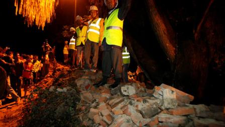 Nepalese rescue workers and people look on after after the British Embassys compound wall collapsed reportedly killing three pedestrians following an earthquake in Katmandu, Nepal, Sunday, Sept. 18, 2011. A strong earthquake with a preliminary magnitude of 6.8 hit northeastern India on Sunday near the border with Nepal. Reports said several people were injured and some buildings fell in the capital of Indias Sikkim state. In neighboring Nepal and Bangladesh, the quake sent residents rushing out their homes, offices and shopping centers. (AP Photo/Binod Joshi)