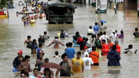 Residents wade through floodwaters as flooding continues for the fourth day Sunday Oct. 2, 2011 at Calumpit township, Bulacan province north of Manila, Philippines. Back-to-back typhoons left at least 55 people dead and rescuers scrambling on Sunday to deliver food and water to hundreds of villagers stuck on rooftops for four days because of flooding in the northern Philippines.