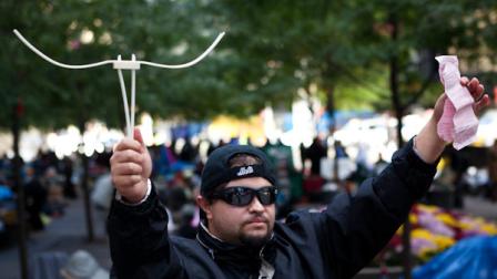 Michael Pellagatti, of Jersey City, N.J., holds the plastic handcuffs police used to arrest him for disorderly conduct while marching on the Brooklyn bridge along with the resultant court summons, Sunday, Oct. 2, 2011, in New York. Over 700 protestors from the Occupy Wall Street protests camping in nearby Zucotti park were arrested when they marched on the Brooklyn bound lanes while protesting against corporate greed. (AP Photo/John Minchillo)