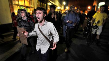 Demonstrators with Occupy Boston march toward the police station where fellow demonstrators were brought after police arrested people sleeping in an expansion of the Occupy Boston tent village in Boston, in the early morning hours of Tuesday, Oct. 11, 2011.