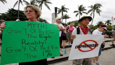 Marilyn Bernardy left, and Manny Paz right, join hundreds of demonstrators protesting for Occupy Florida at the Torch of Friendship on Saturday Oct. 15, 2011 in Miami . The demonstration is one of many being held across the country recently in support of the ongoing Occupy Wall Street demonstration in New York.