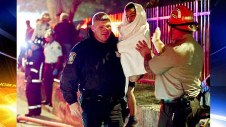 A Boston police officer carries Xavier Lamb, 6, who was dropped by his grandmother from the third floor to a firefighter below, during a pre-dawn fire at a large apartment building in the Roxbury section of Boston Monday, Oct. 17, 2011. Firefighters rescued at least 15 people in the fire that police say may have resulted from a suicide attempt by one of the residents.