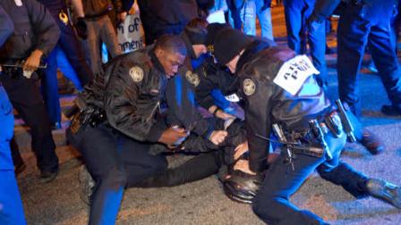 Police make an arrest after Occupy Atlanta protestors and an officer clashed as he was driving through the crowd on a motorcycle Saturday, Nov. 5, 2011 in Atlanta. Police arrested several Occupy Atlanta protesters late Saturday after a rally in a city park spilled into the streets and officers converged on the nearby area on motorcycles, horseback and in riot gear.