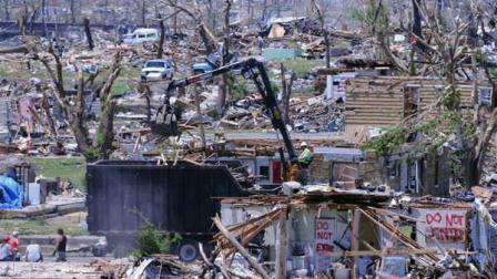 Debris is loaded on a truck near 25th and Jackson in Joplin, Mo, on Wednesday, June 15, 2011. A massive cleanup effort is underway in Joplin after a tornado destroyed much of the southwest Missouri city on Sunday, May 22. (AP Photo/Mike Gullett)