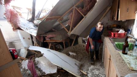 Auburn University student Tabitha Welch helps a friend search her home for valuables after a windstorm blew several trees into her home in Auburn, Ala., Wednesday, Nov. 16, 2011. A path of storms swept across the state leaving behind fallen trees and some heavy wind damage. (AP Photo/Dave Martin)