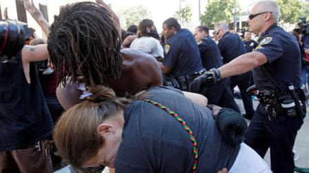 Two demonstrators cover themselves after San Diego Police used pepper spray during a protest at the Civic Center Plaza Friday, Oct. 14, 2011 in San Diego. Police on Friday began removing about a half-dozen tents after warning demonstrators that their personal belongings couldnt stay in the Occupy San Diego camp. (AP Photo/Lenny Ignelzi)