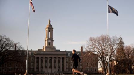 A runner passes in front of the Old Main administration building on Penn States University Park campus Friday, Nov. 18, in State College, Pa. Days after losing the job he held for nearly a half century, former Penn State coach Joe Paterno was diagnosed with a treatable form of lung cancer on Friday. (AP Photo/Andy Colwell)