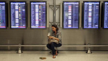 Victoria Puerto checks her flight information and tickets while waiting for her flight at the Miami International Airport in Miami, Tuesday, Nov. 22, 2011. She was traveling today to avoid the Thanksgiving holiday rush later in the week.