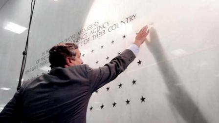 In this May 23, 2002, file photo Director of the Central Intelligence Agency George Tenet reaches out to touch a five-pointed star freshly carved into the marble-faced lobby wall of CIA headquarters in Langley, Va. The star, the 79th, honors CIA officer Johnny Mike Spann, killed during a November 2001 prison uprising in Afghanistan by al-Qaida members. Since then a total of 23 stars have been added to the wall, and in a rare break of the silence that surrounds the families of the clandestine community, the CIA Officers Memorial Foundation notes about 56 children of those killed in the line of duty will need educational support.