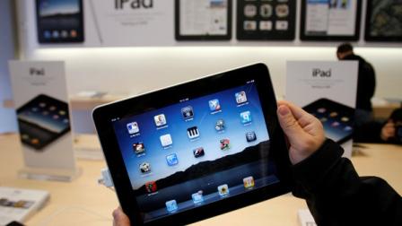 A man using a cell phone passes an AT&T store, Tuesday, Oct. 18, 2011 in New York. AT&T Inc. on Thursday, Oct. 20, 2011, reported a decline in the number of iPhones activated in its latest quarter, as buyers waited for the new model. (AP Photo/Mark Lennihan)
