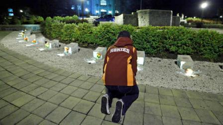 A student participates in an impromptu candlelight vigil in front of the 4/16 memorial on the campus of Virginia Tech after two shootings on the campus in Blacksburg, Va., Thursday, Dec. 8, 2011.