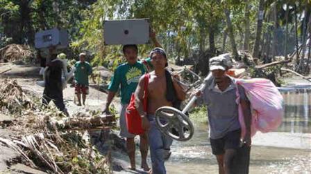 Residents carry their household items they retrieved from their damaged houses Sunday, Dec. 18, 2011 in Iligan city in southern Philippines. Tropical storm Washi blew away Sunday after devastating the southern Philippines with flash floods that killed hundreds of people as they slept and turned two coastal cities into a muddy wasteland filled with overturned cars and uprooted trees.