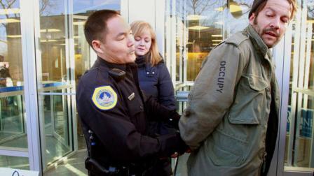 A protester is arrested for blocking the entrance to Republican presidential candidate Mitt Romneys local campaign office during an Occupy The Caucus demonstration in Des Moines, Wednesday, Dec. 28, 2011. (AP Photo/J. David Ake)