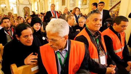 A Syrian woman, left, speaks with an Arab league observer, right, who attends with other observers a mass prayer for the people and army soldiers who were killed during the violence around the country, at the Holy Cross Church, in Damascus, Syria, on Monday Jan. 9, 2012.