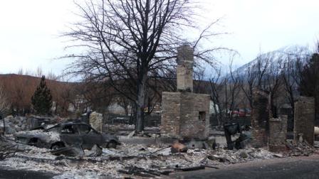A burned car and debris is scattered around what is left of a house on Friday, Jan. 20, 2012 in Pleasant Valley, south of Reno, Nev. The area remains closed, as seen on Friday, Jan. 20, 2012. The blaze started shortly after noon Thursday and, fueled by wind gusts reaching 82 mph, mushroomed to more than 6 square miles before firefighters stopped its surge toward Reno. (AP Photo/Cathleen Allison)