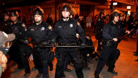 Oakland Police officers stand guard as other officers arrest a protester during an anti-police protest by Occupy Oakland, Saturday, Jan. 28, 2012, in Oakland, Calif. Oakland police said they arrested about 300 people Saturday as protesters spent a portion of the day trying to get into a vacant convention center, and later broke into City Hall and tried to occupy a YMCA. (AP Photo/Beck Diefenbach)