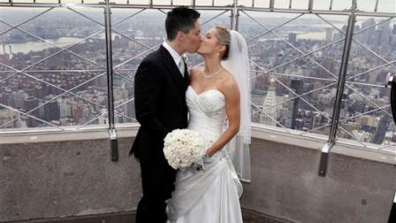 Lela Mc Arthur, left, and Stephanie Figarelle, of Anchorage, Ak., pose for photos on the observation deck after their Valentines Day wedding ceremony at the Empire State Building, in New York, Tuesday, Feb. 14, 2012.