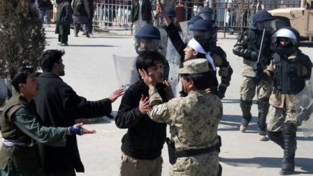 An Afghan policeman calms down a protestor during an anti-U.S. demonstration in Kunduz, north of Kabul, Afghanistan, Saturday, Feb. 25, 2012. At least 25 people have been killed and hundreds wounded since Tuesday, when it first emerged that Qurans and other religious materials had been thrown into a fire pit used to burn garbage at Bagram Air Field, a large U.S. base north of Kabul.(AP Photo/Ezatullah Pamir)