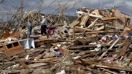 Ashley Thomas, left, and Katie Paben look over the remains of Thomas home in Henryville, Ind., Saturday, March 3, 2012 after a tornado hit the area on Friday. Severe storms, predicted by forecasters for days, killed dozens of people in five states - Alabama, Georgia, Indiana, Kentucky and Ohio. (AP Photo/Michael Conroy)