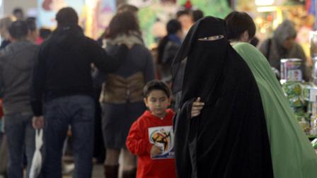 A Muslim woman wearing a burqa shops at a local market in Sydney Sunday, July 10, 2011.
