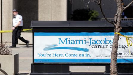 A Columbus police officer walks past Miami-Jacobs Career College where a stabbing occurred Wednesday, March 14, 2012, in Columbus, Ohio. The stabbing suspect was shot in the street after stabbing four people in an attack that started inside the college.