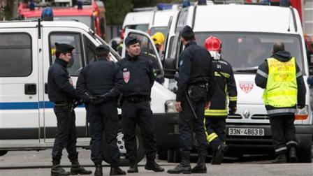 Police officers stand near a building in Toulouse, France, Wednesday March 21, 2012 where a suspect in the shooting at the Ozar Hatorah Jewish school is barricaded in an apartment building.