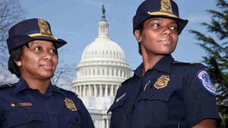 Officers Yogananda Yogi Pittman, left, and Monique Moore, right, the first two African-American women to be promoted to the rank of captain on the U.S. Capitol Police force, stand together on the East Lawn of the Capitol in Washington, Monday, March 19, 2012. (AP Photo/J. Scott Applewhite)