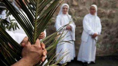 Catholic nuns wait to participate in the traditional Palm Sunday procession on the Mount of Olives overlooking Jerusalems old city, Sunday, April 1, 2012. Palm Sunday marks for Christians, Jesus Christs entrance into Jerusalem, when his followers laid palm branches in his path, prior to his crucifixion. (AP Photo/Ariel Schalit)