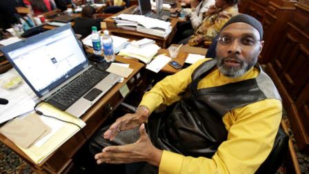 Rep. Ako Abdul-Samad, D-Des Moines, sits at his desk in the Iowa House Wednesday, April 4, 2012, at the Statehouse in Des Moines, Iowa. State patrol officers stopped anyone from entering or leaving the Statehouse on Tuesday evening after Abdul-Samad opened an envelope at his desk and powder spilled out. After about four hours officers announced the powder had been deemed harmless and that people could leave the building.